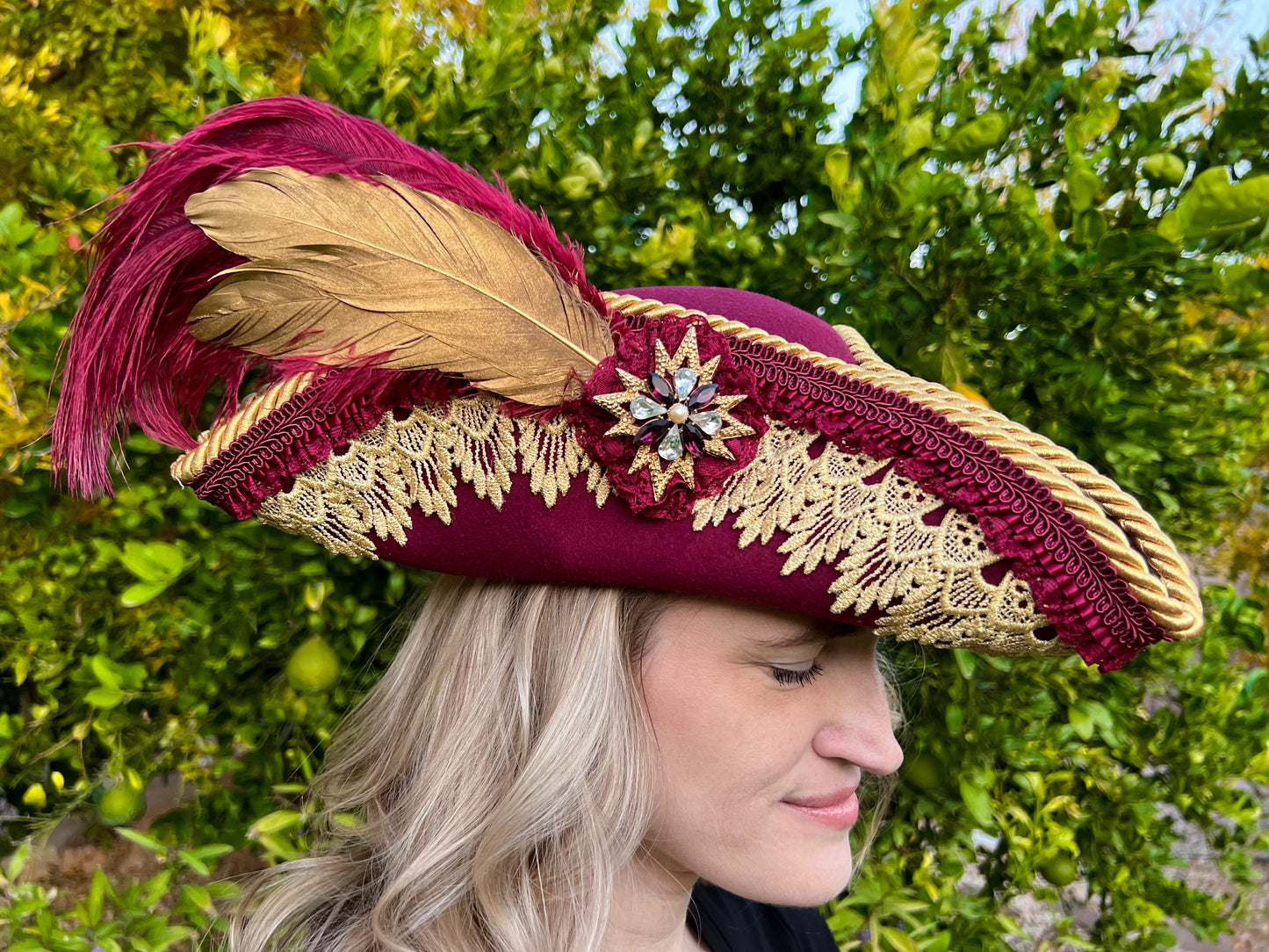 Tricorn Hat 22" Maroon Polyester Base with Gold Trim, Feathers, and Spiked Brooch